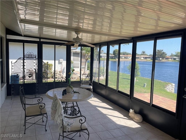 unfurnished sunroom with a ceiling fan and a water view