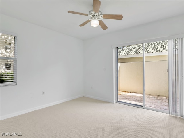 unfurnished bedroom with carpet floors, multiple windows, baseboards, and a ceiling fan