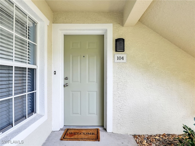 doorway to property featuring stucco siding