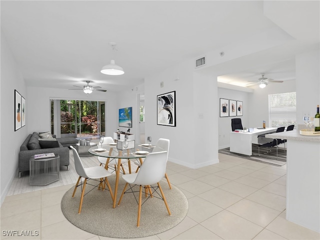 dining area with light tile patterned floors, ceiling fan, visible vents, and baseboards