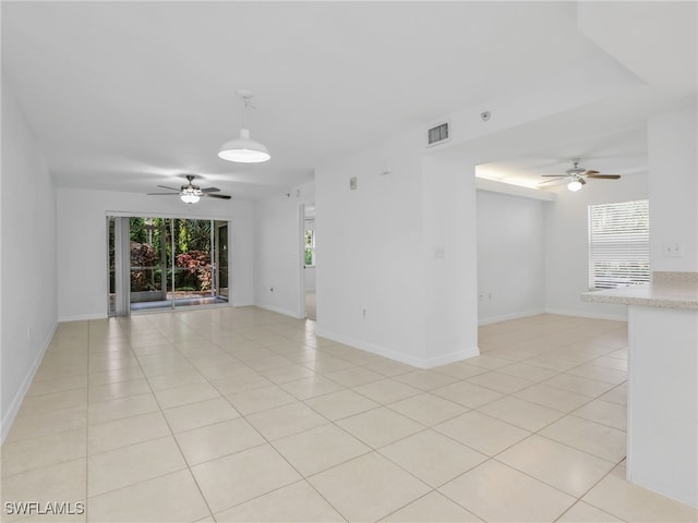 unfurnished room with light tile patterned floors, ceiling fan, visible vents, and baseboards