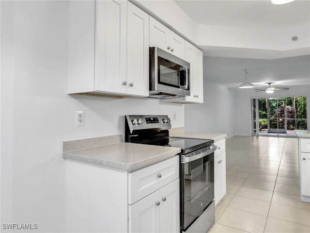 kitchen featuring light tile patterned floors, light countertops, appliances with stainless steel finishes, open floor plan, and white cabinetry