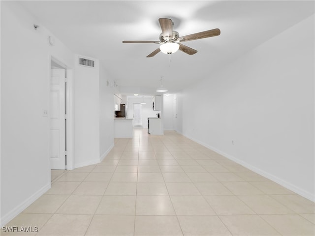 unfurnished living room with light tile patterned floors, baseboards, visible vents, and a ceiling fan