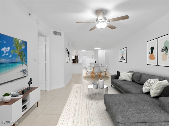 living room featuring light tile patterned floors, baseboards, visible vents, and a ceiling fan