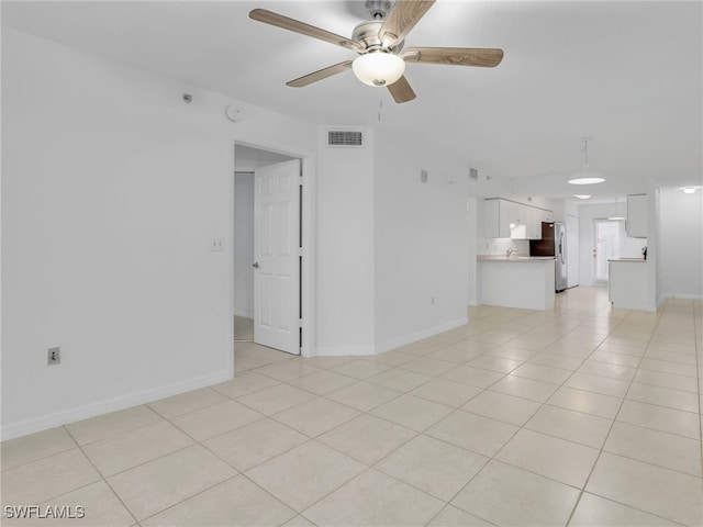 unfurnished living room featuring a ceiling fan, visible vents, baseboards, and light tile patterned floors