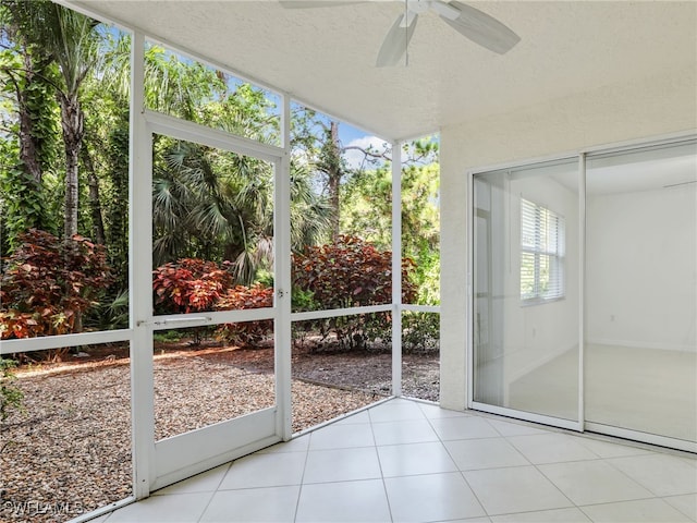 unfurnished sunroom featuring ceiling fan