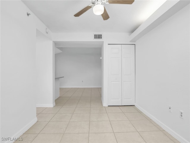 unfurnished bedroom featuring light tile patterned floors, a closet, visible vents, and baseboards