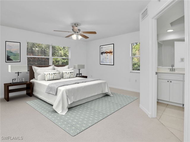 bedroom with visible vents, a sink, light carpet, and multiple windows