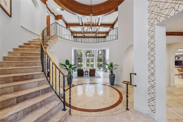 foyer entrance with arched walkways, an inviting chandelier, and baseboards