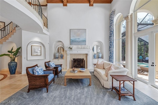 living area featuring baseboards, a towering ceiling, tile patterned floors, french doors, and a fireplace