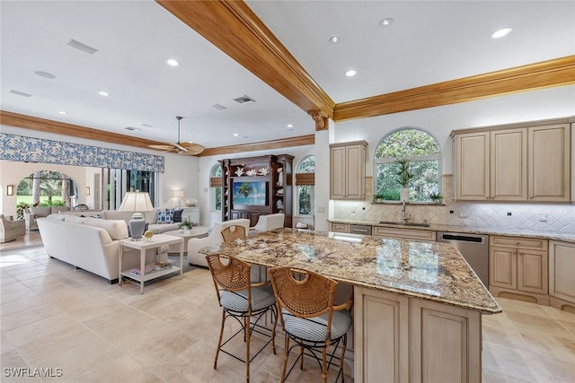 kitchen featuring stainless steel dishwasher, a sink, a wealth of natural light, and decorative backsplash