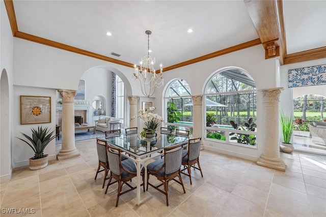 dining space with ornamental molding, a fireplace, visible vents, and ornate columns