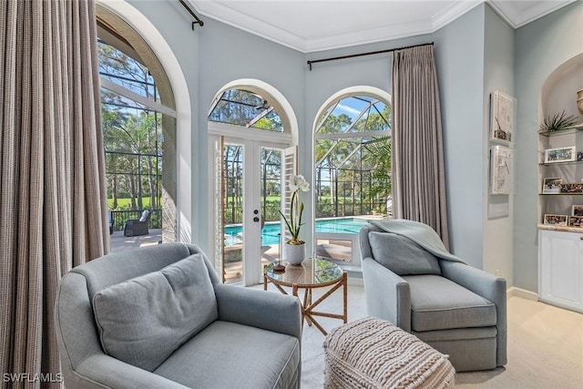 living area featuring baseboards, carpet floors, french doors, and crown molding