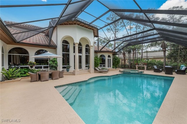 view of pool featuring a patio, a lanai, and a pool with connected hot tub