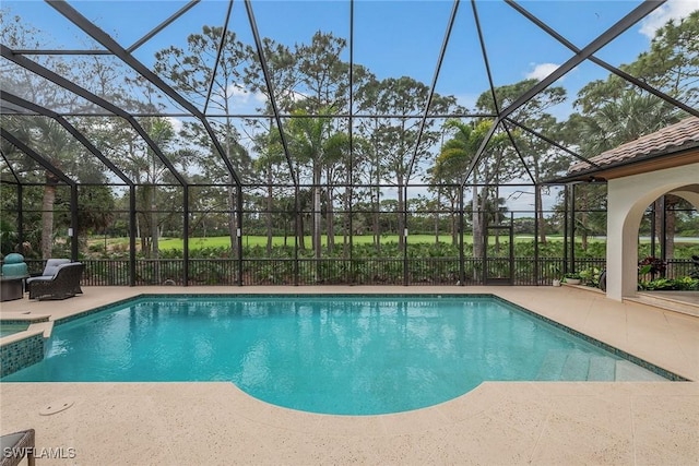 view of swimming pool featuring a pool with connected hot tub, a patio, and a lanai