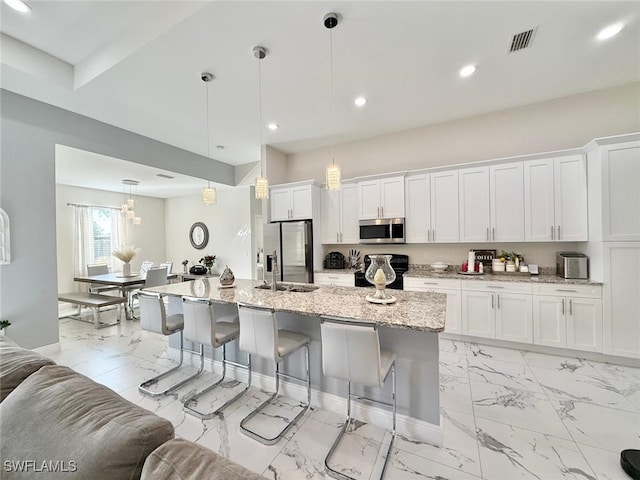 kitchen with a sink, marble finish floor, white cabinetry, and stainless steel appliances