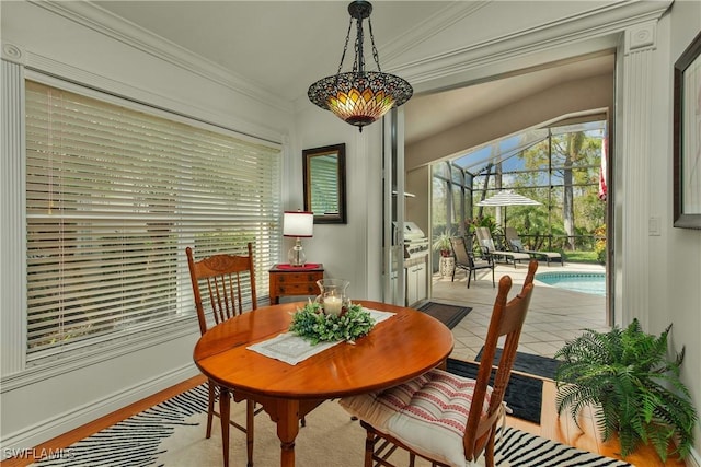 tiled dining area with a sunroom and ornamental molding