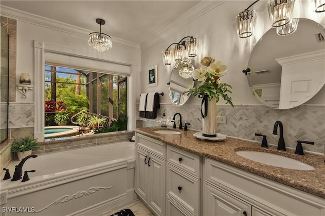 bathroom with a chandelier, crown molding, a sink, and a garden tub