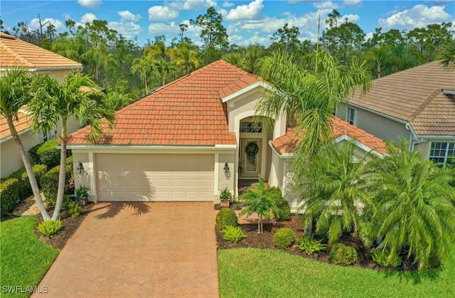 mediterranean / spanish-style home featuring a garage, a tiled roof, driveway, and stucco siding