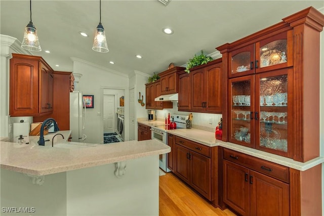 kitchen featuring range with electric stovetop, lofted ceiling, freestanding refrigerator, a peninsula, and under cabinet range hood