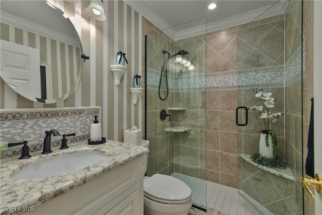 bathroom with ornamental molding, a tile shower, toilet, and wallpapered walls