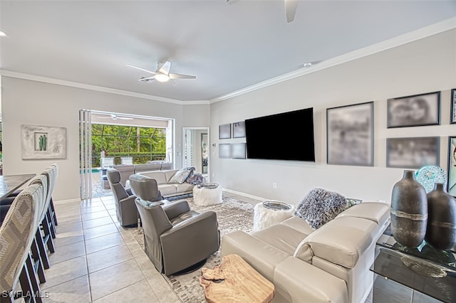 living area featuring light tile patterned floors, ornamental molding, a ceiling fan, and baseboards