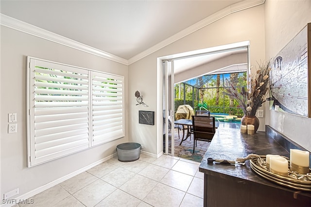 interior space with light tile patterned floors, ornamental molding, a sunroom, vaulted ceiling, and baseboards