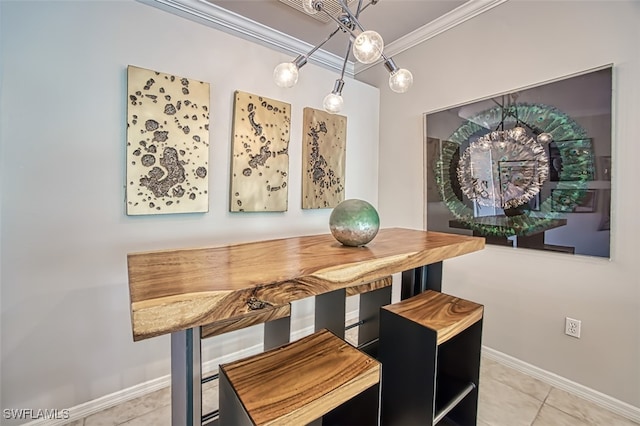 dining room featuring tile patterned flooring, ornamental molding, and baseboards