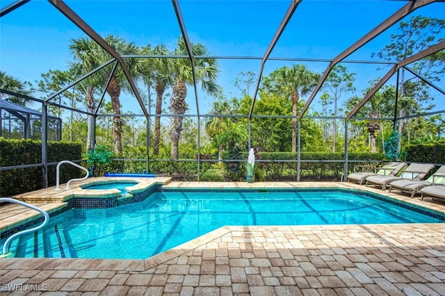 view of swimming pool featuring glass enclosure, a pool with connected hot tub, and a patio