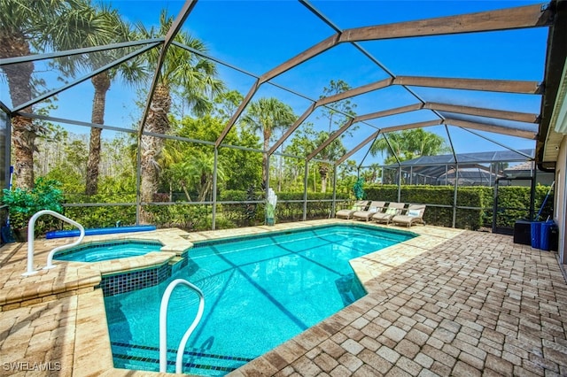 view of swimming pool featuring a lanai, a pool with connected hot tub, and a patio