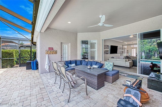 view of patio / terrace with ceiling fan, a lanai, and an outdoor living space