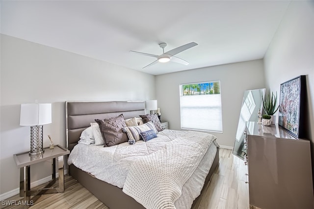 bedroom featuring ceiling fan, light wood-style flooring, and baseboards