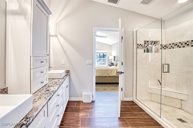 bathroom featuring ensuite bathroom, wood finish floors, a sink, and a shower stall