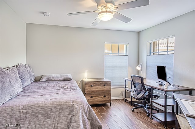 bedroom with dark wood-type flooring, ceiling fan, and baseboards