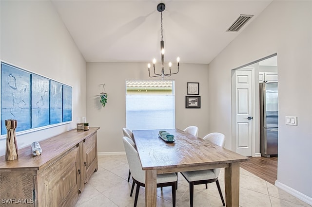 dining area featuring light tile patterned floors, baseboards, visible vents, an inviting chandelier, and vaulted ceiling