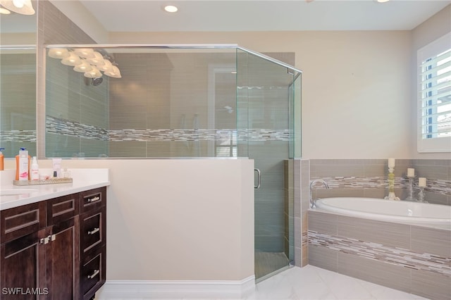 full bathroom featuring a stall shower, a garden tub, and vanity