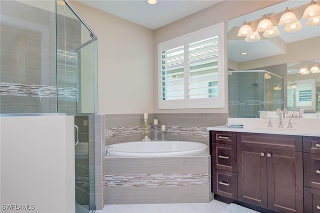 full bathroom featuring a garden tub, a shower stall, and vanity