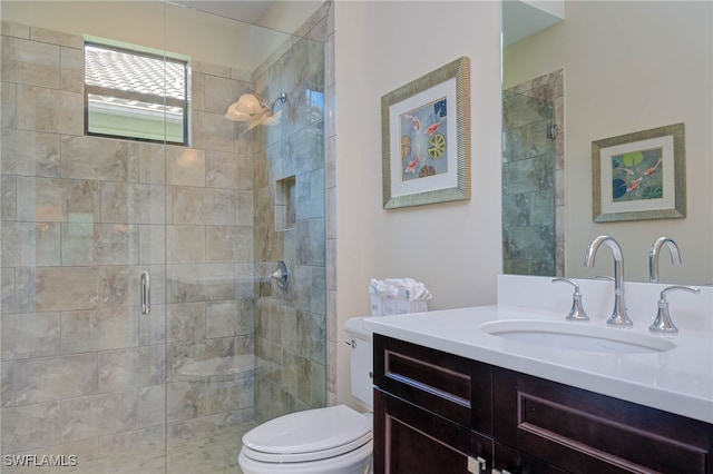 bathroom with a stall shower, vanity, and toilet