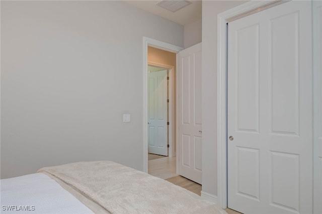 bedroom featuring light wood finished floors and visible vents