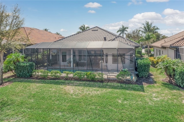 back of house with an outdoor pool, a lanai, a tile roof, and a lawn