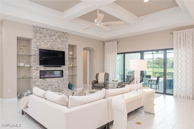 living area featuring built in features, arched walkways, a fireplace, coffered ceiling, and beamed ceiling