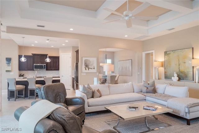 living room with coffered ceiling, visible vents, and a ceiling fan