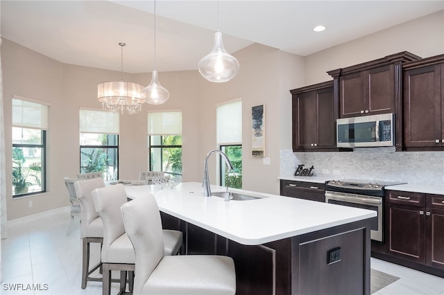 kitchen featuring backsplash, stainless steel appliances, a sink, and light countertops