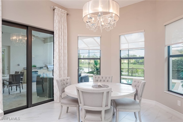 dining room with marble finish floor, baseboards, and an inviting chandelier