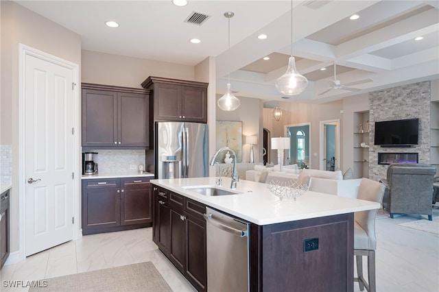 kitchen with open floor plan, appliances with stainless steel finishes, a sink, and visible vents