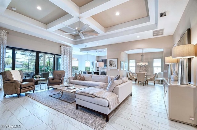 living area featuring visible vents, a healthy amount of sunlight, coffered ceiling, and a high ceiling