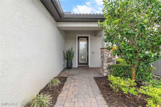 doorway to property featuring stucco siding