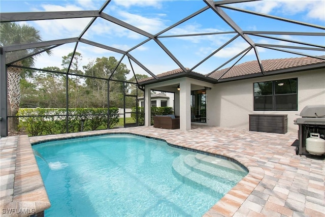 outdoor pool with glass enclosure, a patio area, and area for grilling