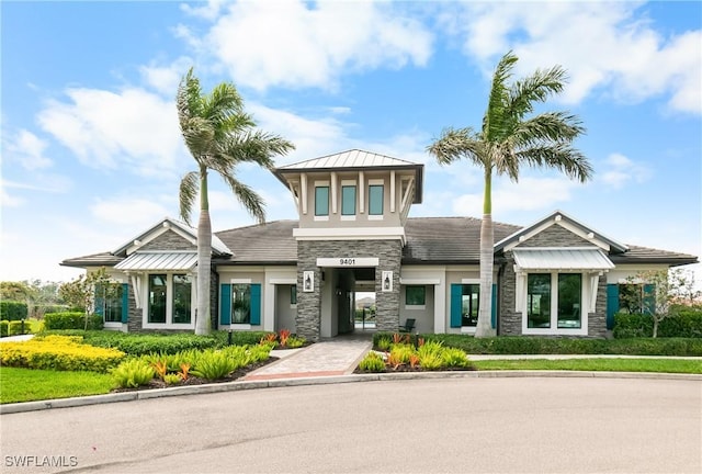 view of front of property with metal roof, a standing seam roof, stone siding, and stucco siding