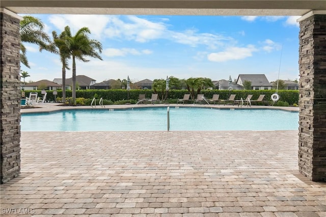 pool with a patio area and fence